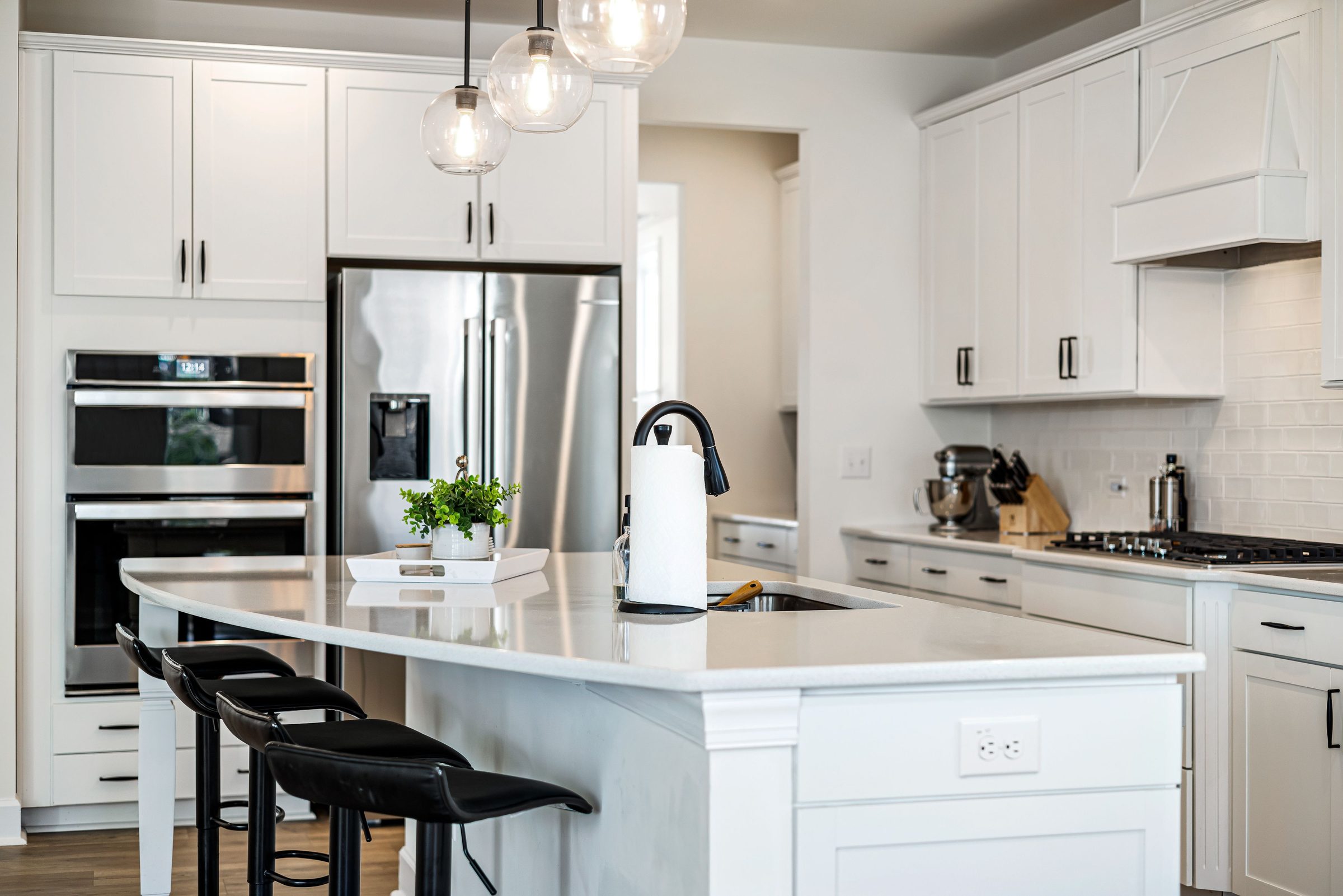 A bright, modern kitchen with a marble island and pendant lighting